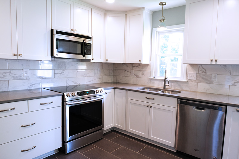 white kitchen, marble back splash, large grey tile floor