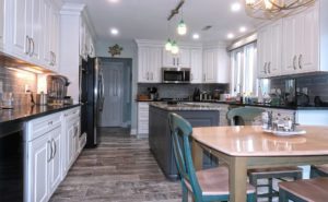 Kitchen remodel, two tone cabinets, wood look tile floor, opened up to living area.