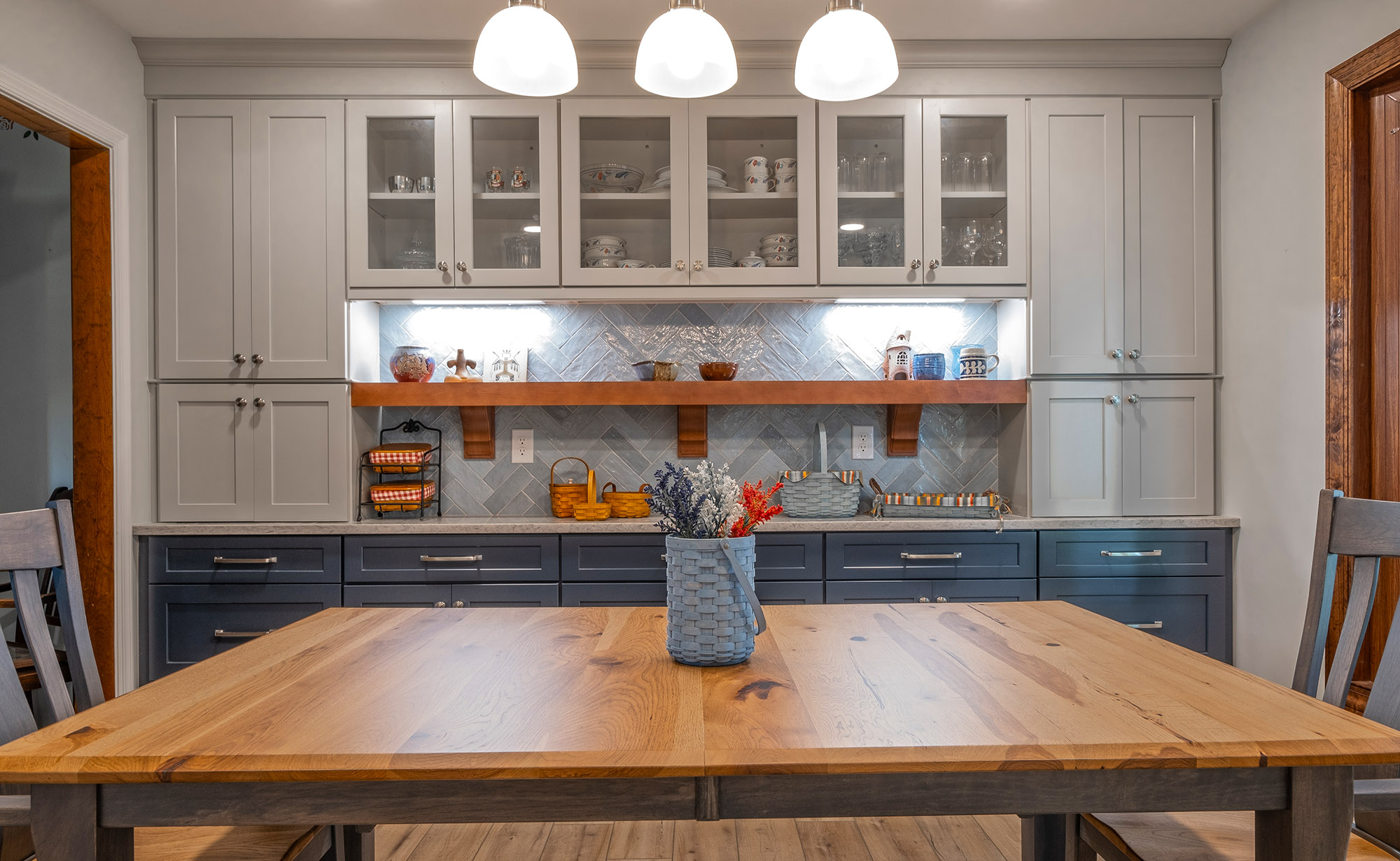 Eat-in kitchen area with built in cabinets, tiled backsplash and floating shelf.