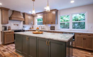 Kitchen remodel with two tone cabinets with large island, pot filler and custom range hood.